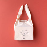 Stofftasche mit Hasengesicht und offenen Griffen auf rotem Hintergrund.