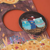 Nahaufnahme eines runden Puzzleteils: drei kleine Eulen im Nest.