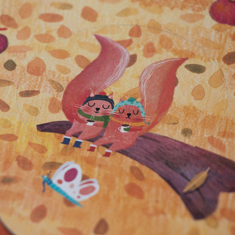 Nahaufnahme eines Puzzleteils: zwei Eichhörnchen sitzen auf einem Ast, trinken Tee und tragen Schals und Mützen.