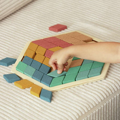 Kind legt Mosaik Teile aus Kork