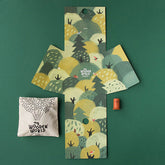 Verpackungsinnenseite mit Waldillustrationen, Stoffbeutel und einer Holzfigur.