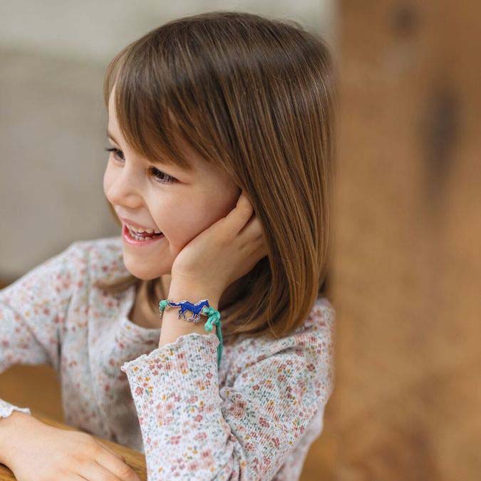 Kind trägt Stimmungsarmband mit Pferdeanhänger