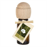 Raumduftflasche mit Holzaufsatz und Etikett Blumenwiese, zeigt eine weiße Blüte im Gras.