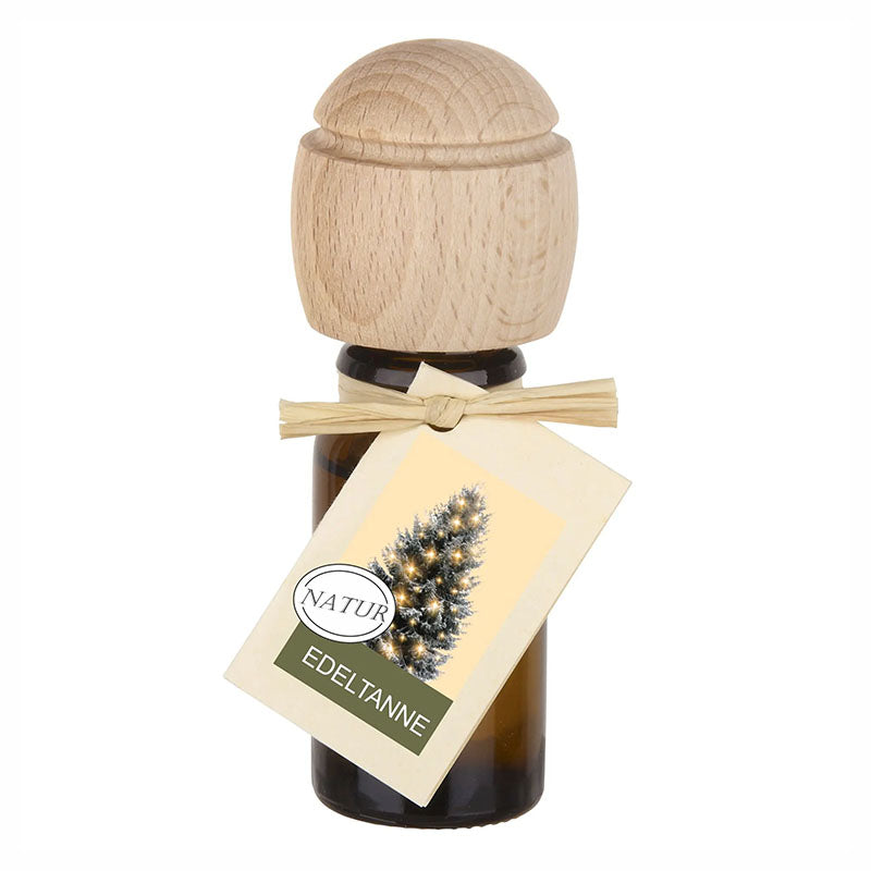 Raumduftflasche mit Holzaufsatz und Etikett Edeltanne, mit Bild eines geschmückten Tannenbaums.