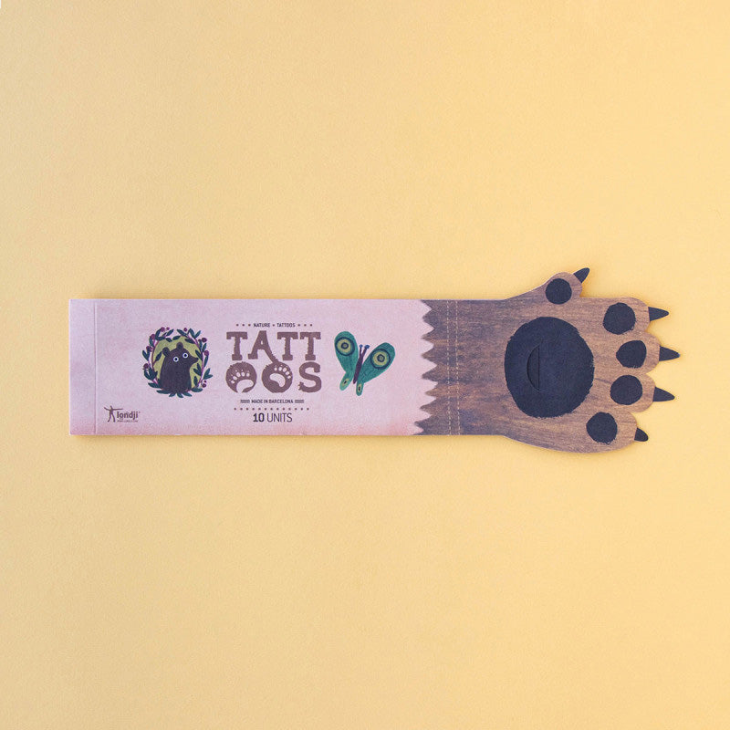 Verpackung der Tattoos von oben, im Tatzen-Design mit der Aufschrift „Tattoos“.