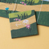 Spielplättchen mit einem Weg, Blumen und einem Würfel-Symbol mit Pfeil.