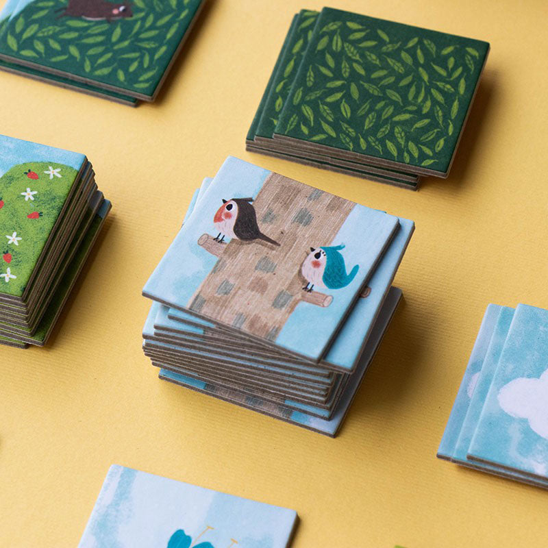 Nahaufnahme von gestapelten Spielkarten mit Vogel-Illustrationen auf Ästen.