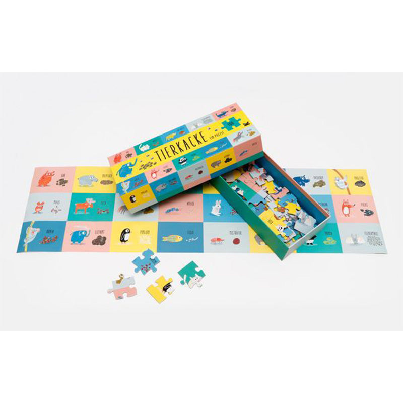 Puzzlebox neben einem weitgehend zusammengesetzten Puzzle, bunte Tierfelder sichtbar.