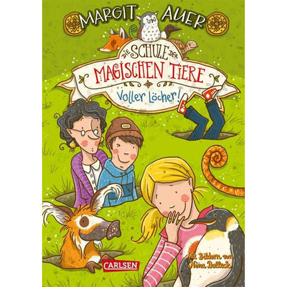 Buchcover: Titel „Die Schule der magischen Tiere – Voller Löcher!“ – zeigt Kinder und Tiere auf einer grünen Wiese, aus der viele Löcher gegraben sind. Miss Cornfield, zwei Kinder und die Tiere (u.a. ein Erdmännchen und ein Pinguin) blicken neugierig.