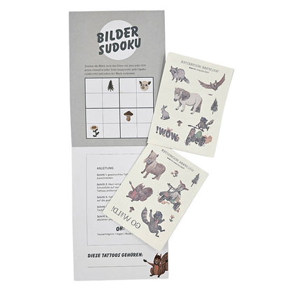 Offene Mappe mit zwei Bögen Waldpark Hochreiter-Tattoos und einem gezeichneten Bilder-Sudoku-Spiel.