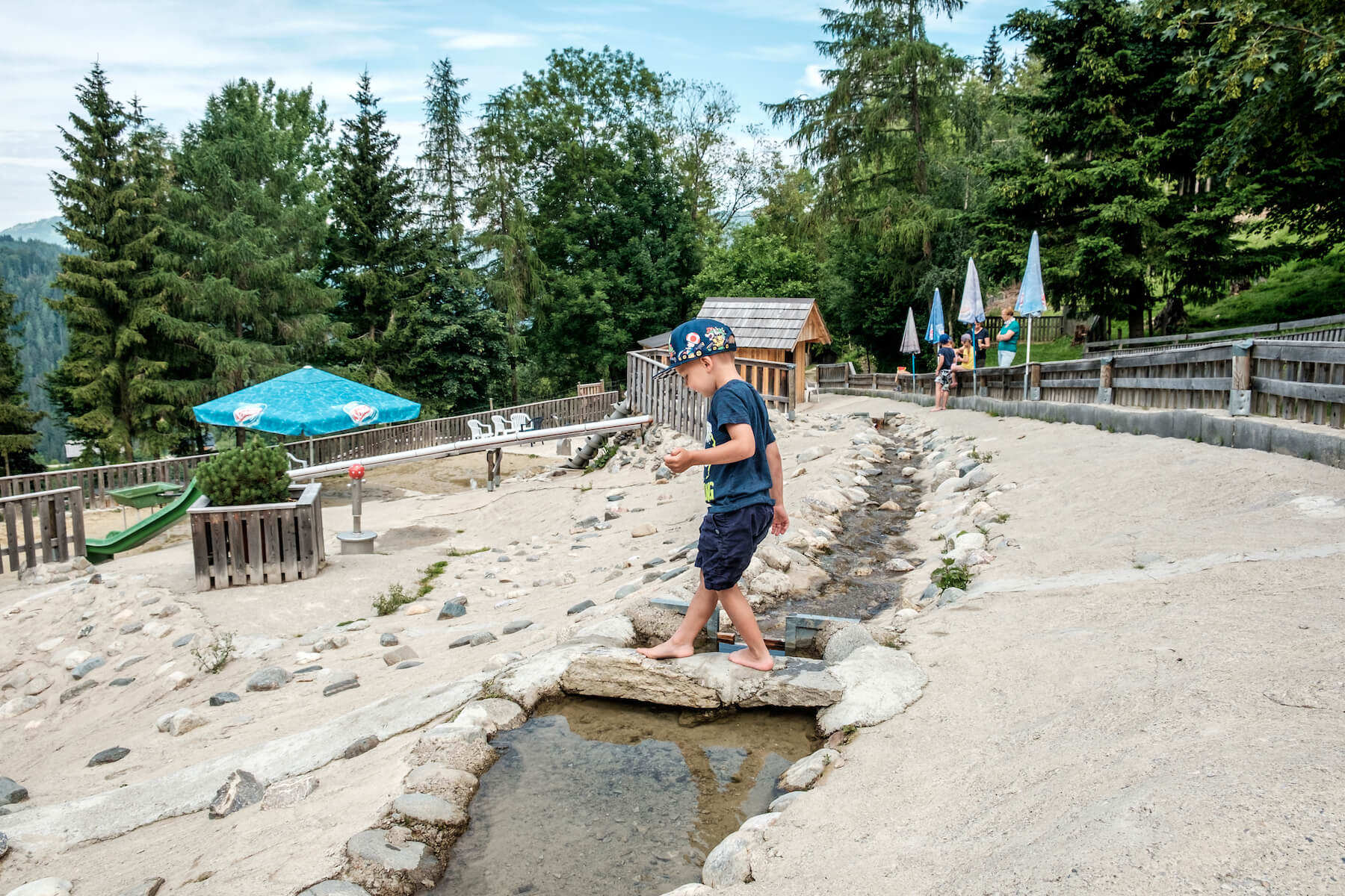 Wasserspielplatz Junge balanciert