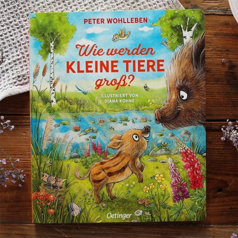 „Wie werden kleine Tiere groß?“ von Peter Wohlleben, Coverillustration mit Frischling und Wildschwein am Teich, umgeben von bunten Blumen und Waldtieren.