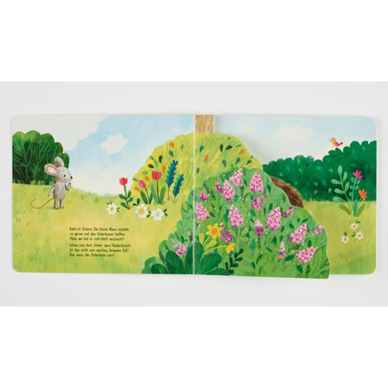 Buchseite: Eine kleine Maus steht auf einer Wiese vor einem blühenden Busch und sucht den Osterhasen – hinter den Blumen ist ein braunes Fell zu sehen.