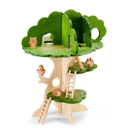 Holz-Spielbaum mit mehreren Ebenen, grünen Baumkronen, Leitern und kleinen Holzfiguren wie Eule, Igel und Vogel.