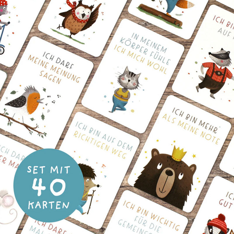 Mehrere Affirmationskarten flächig ausgelegt auf Holzhintergrund mit Tierillustrationen, positiven Botschaften und Hinweis auf ein Set mit 40 Karten