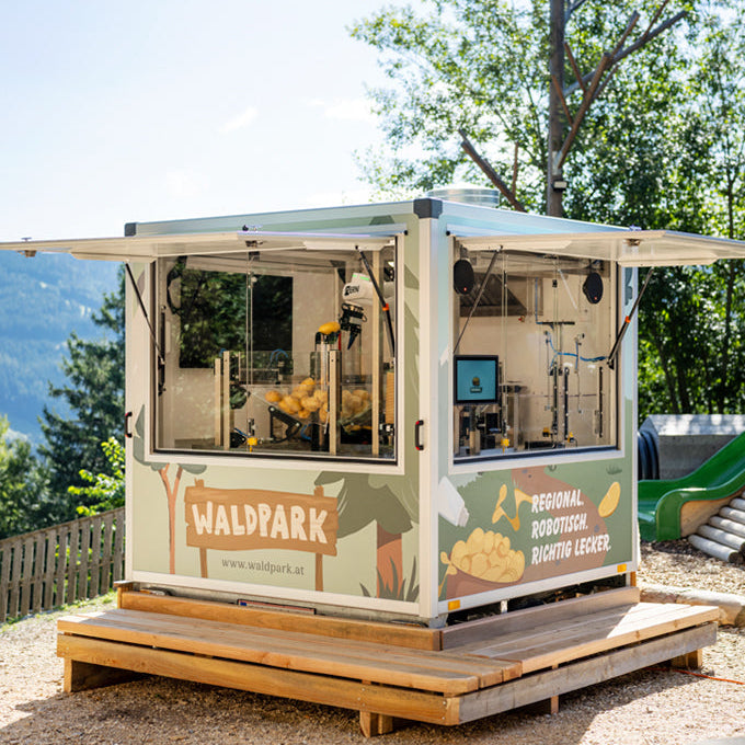 Chipsi der Chipsroboter steht am Holzfäller Trail im Waldpark Hochreiter