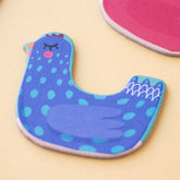 Detailansicht einer blauen Hühnerfigur aus Karton mit Punkten und geschlossenen Augen.