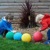 Kinder spielen mit easy Grip bällen draussen in allen vier Farbvarianten