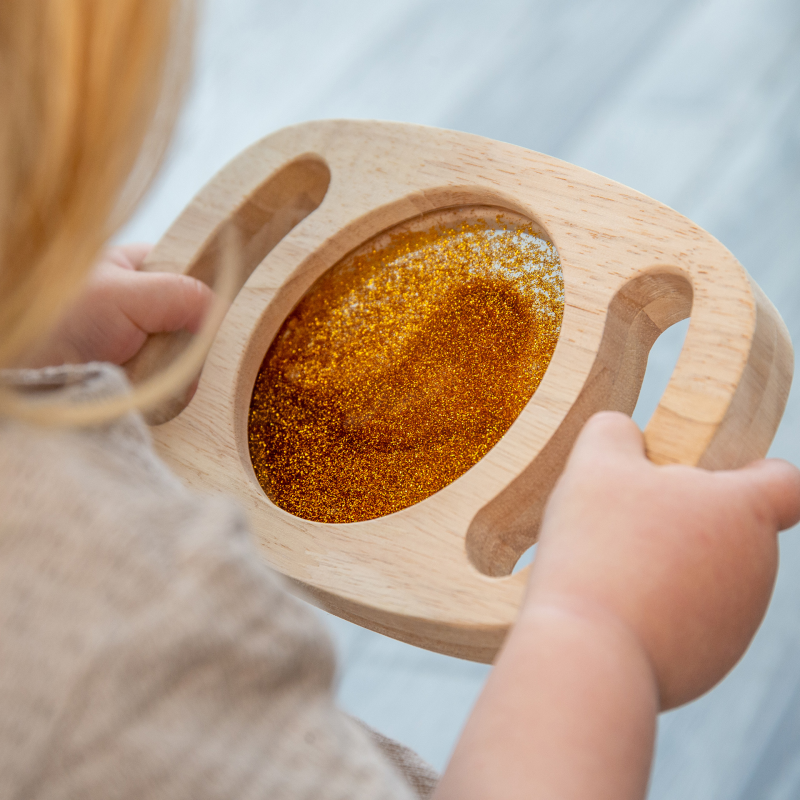 Kleinkind hält goldene Easy Hold Glitzertafel in der Hand