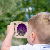 Kleinkind hält lila Glitzertafel in der Hand