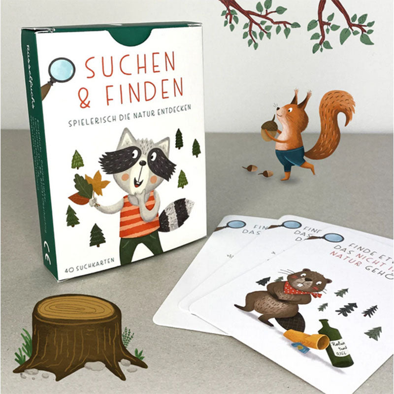 Produktfoto der Kartenbox Suchen und Finden mit aufgelegten Suchkarten, Waldillustrationen, Eichhörnchenfigur, Baumstumpf und Naturmotiven auf hellem Untergrund