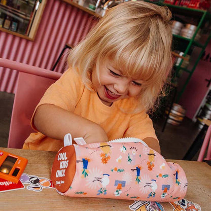 Kind spielt am Tisch mit Federmappe in der Farbe Flore