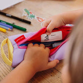 Kind schaut in Federmappe in der Farbe Mini Mauve und sucht mit der Hand nach Stiften