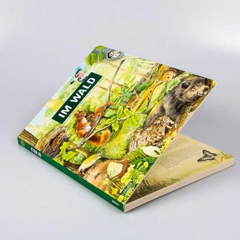 Geöffnetes Buch „Im Wald“ liegt schräg auf dem Tisch, Einblick in erste Innenseite.