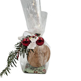 Geschenkset im Zellophan mit Holzanhänger ‚ein braves Christkindl‘, dekoriert mit roten Kugeln und Tannenzweig.