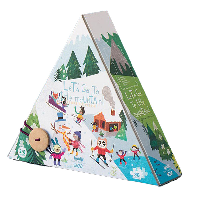 Pyramidenförmige Puzzleverpackung mit winterlichem Bergmotiv, Kindern auf Skiern und einer Hütte im Wald, auf weißem Hintergrund freigestellt.