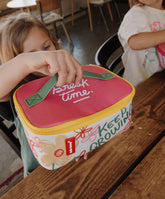 kind nimmt lunchtasche mit blumen vom Tisch