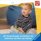 Kleines Kind sitzt auf dem Boden und schaut ein Ravensburger Fühlbuch an.