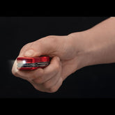 Licht des roten multitool anhänger schaut in die Kamera während Hand den Knopf drückt