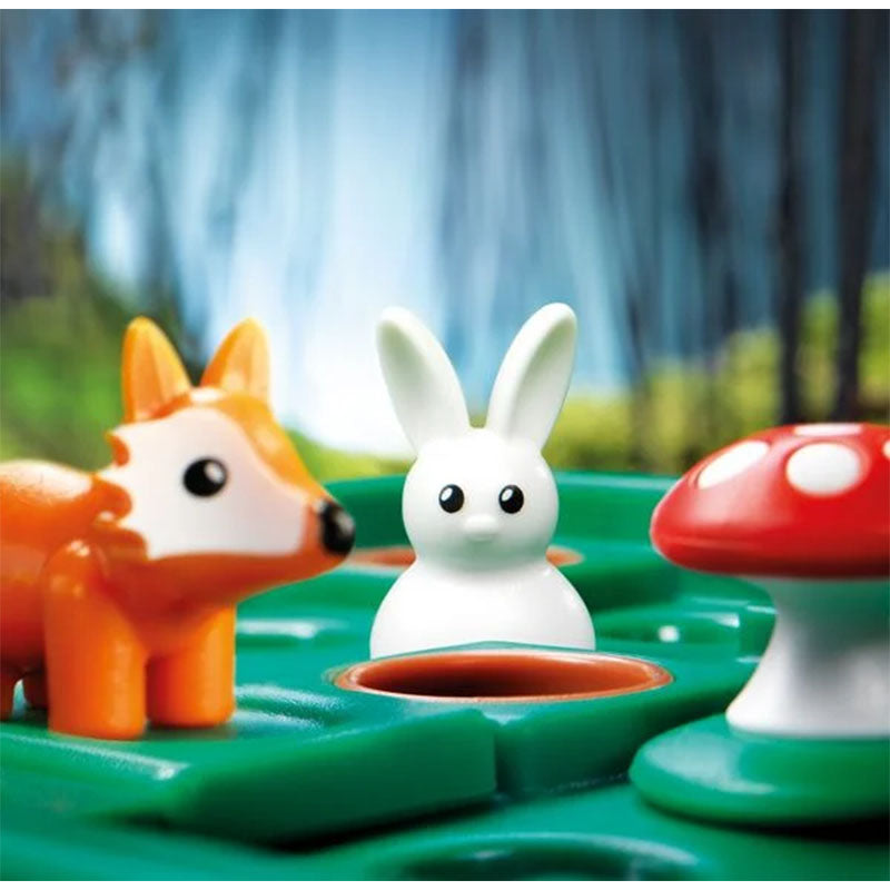 Nahaufnahme des Spiels mit einem weißen Hasen, einem orangefarbenen Fuchs und einem roten Pilz auf dem grünen Spielfeld.