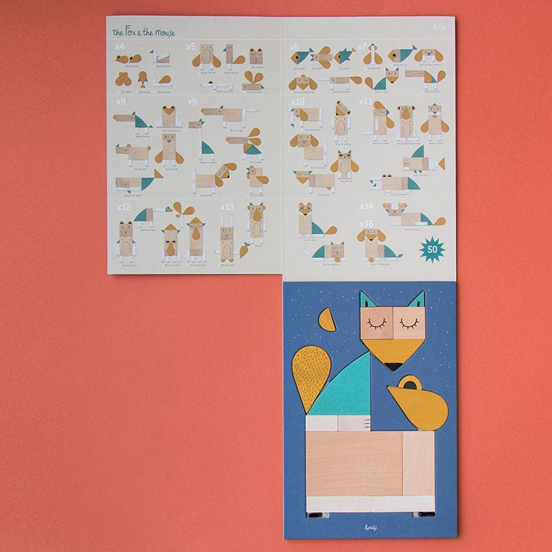 Aufgeklapptes Puzzle-Set mit Anleitung – verschiedene Tiere, die aus den Holzformen zusammengesetzt werden können, sowie ein fertiger Fuchs unten auf blauem Hintergrund.