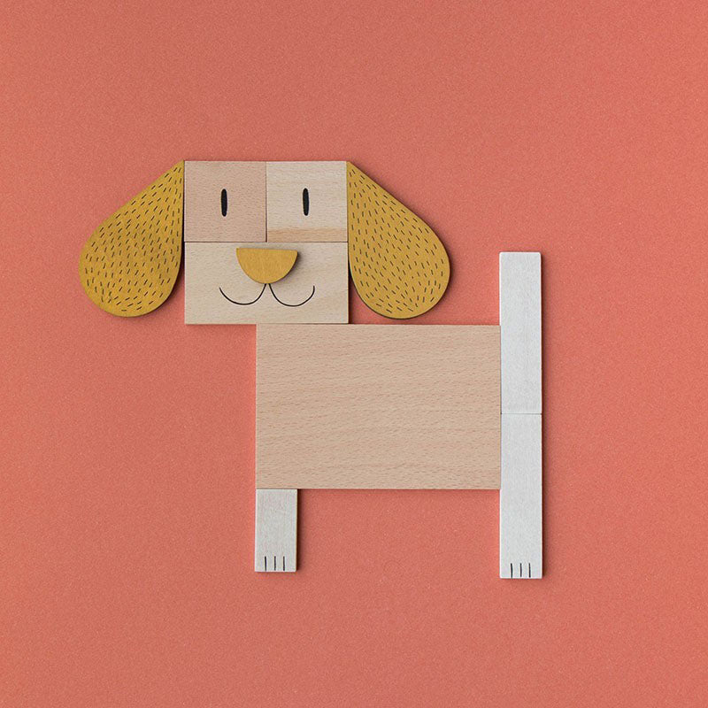 Komplettes Hundemotiv aus Holzformen mit langen Ohren und fröhlichem Gesicht auf orangem Hintergrund.