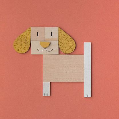 Komplettes Hundemotiv aus Holzformen mit langen Ohren und fröhlichem Gesicht auf orangem Hintergrund.