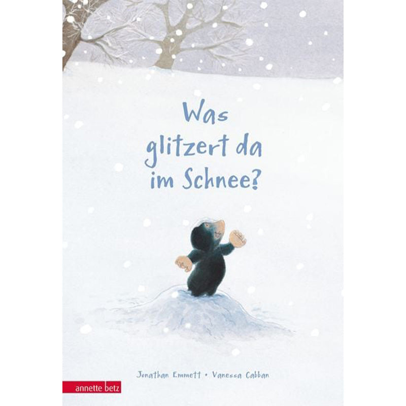 Was glitzert da im Schnee?“ – Ein kleiner Maulwurf steht im Schnee und blickt nach oben, umgeben von sanft fallenden Schneeflocken.