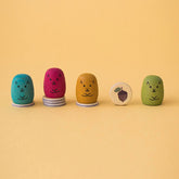 Spielfiguren in allen vier Farben mit gesammelten Spielchips in Form von Eicheln.