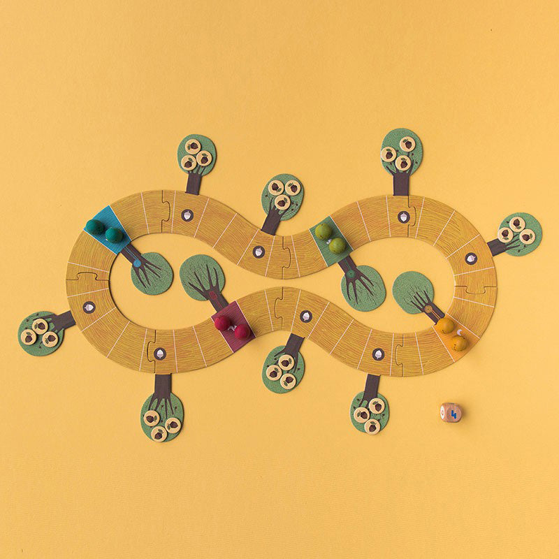 Komplett aufgebautes Spielfeld mit bunten Spielfiguren und Würfel.