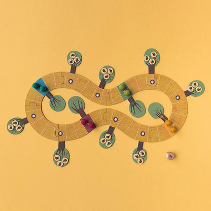 Komplett aufgebautes Spielfeld mit bunten Spielfiguren und Würfel.