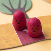 Zwei rote Eichhörnchen-Spielfiguren auf einem Feld.