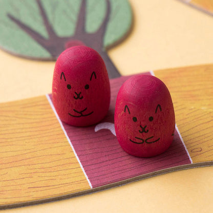 Zwei rote Eichhörnchen-Spielfiguren auf einem Feld.