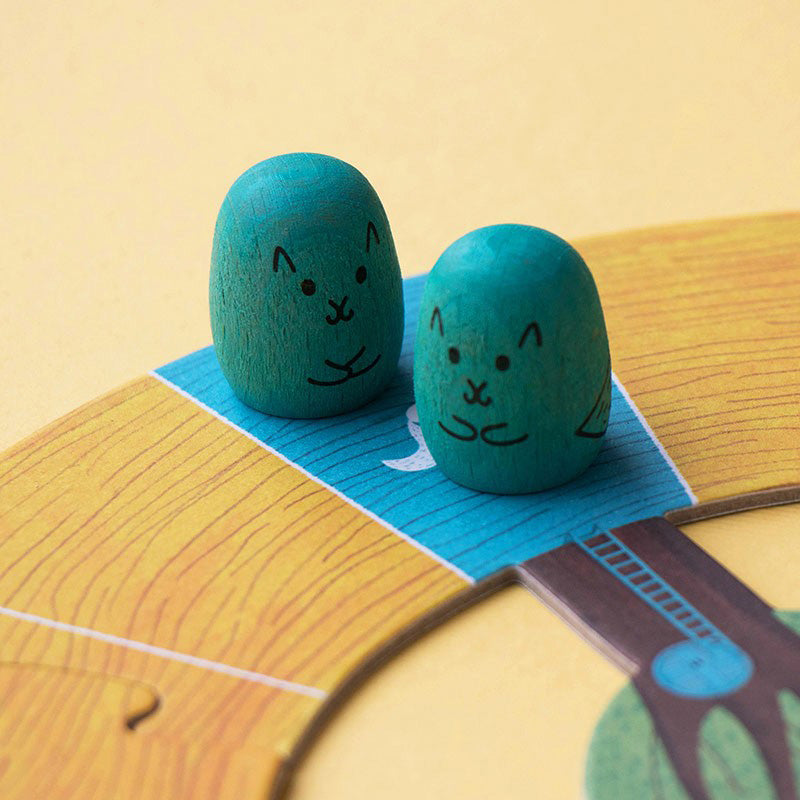 Zwei blaue Eichhörnchen-Spielfiguren auf einem Feld.