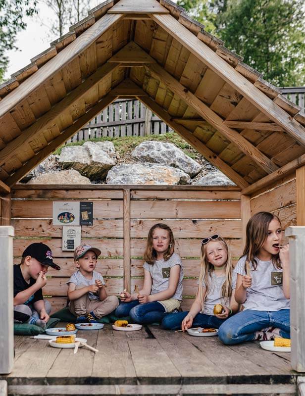 Mehrere Kinder beim Jausnen in einer der Picknickhütten im Waldpark
