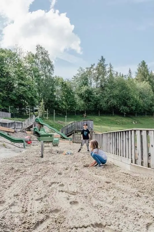 Zwei Kinder beim Spielen im Sand am Wasserspielplatz des Waldpark Hochreiter in der Steiermark